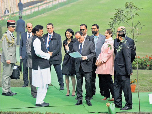 French President Francois Hollande shares a light moment with officials during a visit to Mahatma Gandhi's memorial Rajghat in New Delhi on Monday. PTI