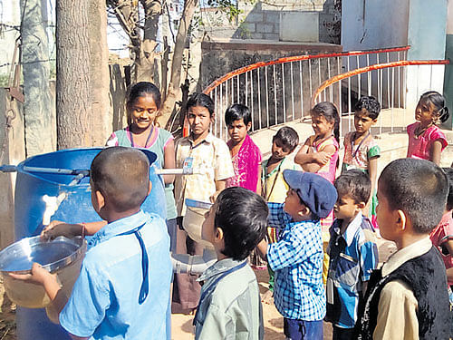 Students wash their plates in aGWH unit after their meals at Muthur Government School in Shidlaghatta.