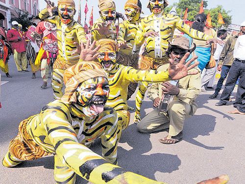 Folk artistes perform 'Tiger Dance' (Huli Kunitha) during a procession organised as part of Basava Jayanti celebrations, in Mysuru, on Monday. DH photo
