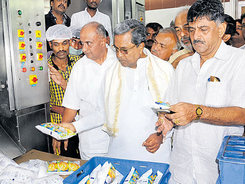 Chief Minister Siddaramaiah looks at a wide range of Nandini products at a unit in Bengaluru on Thursday. Ministers H S Mahadeva Prasad, Ramalinga Reddy, A Manju, D K Shivakumar, BAMUL president K Ramesh and others look on. DH PHOTO
