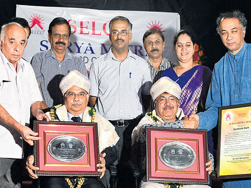 Arun Srivastav, Managing Director and CEO, Syndicate Bank, Bengaluru (left), receives Suryamitra award on behalf of Syndicate Bank, K Subramanya, former CEO of Tata BP  Solar, Bengaluru (right), receives the Suryamitra award  given away by Selco. DH Photo