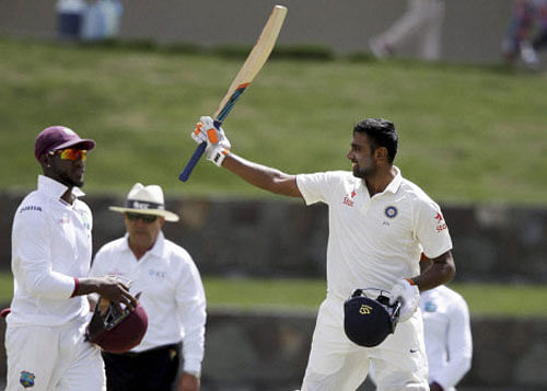 Ravichandran Ashwin raises his bat after scoring a century next to West Indie's Jermaine Blackwood walks during day two of their first cricket Test match at the Sir Vivian Richards Stadium in North Sound, Antigua, Friday, July 22, 2016.AP/PTI