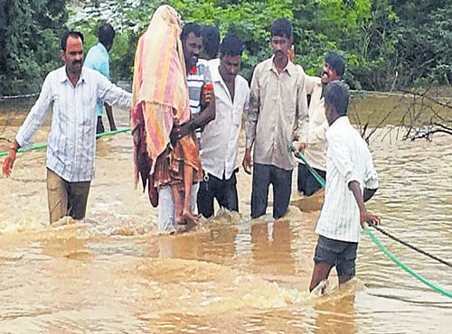 People who were caught in the flood waters of River Kagina near Shankarwadi in Chittapur taluk, Kalaburagi, being rescued on Saturday. DH PHOTO