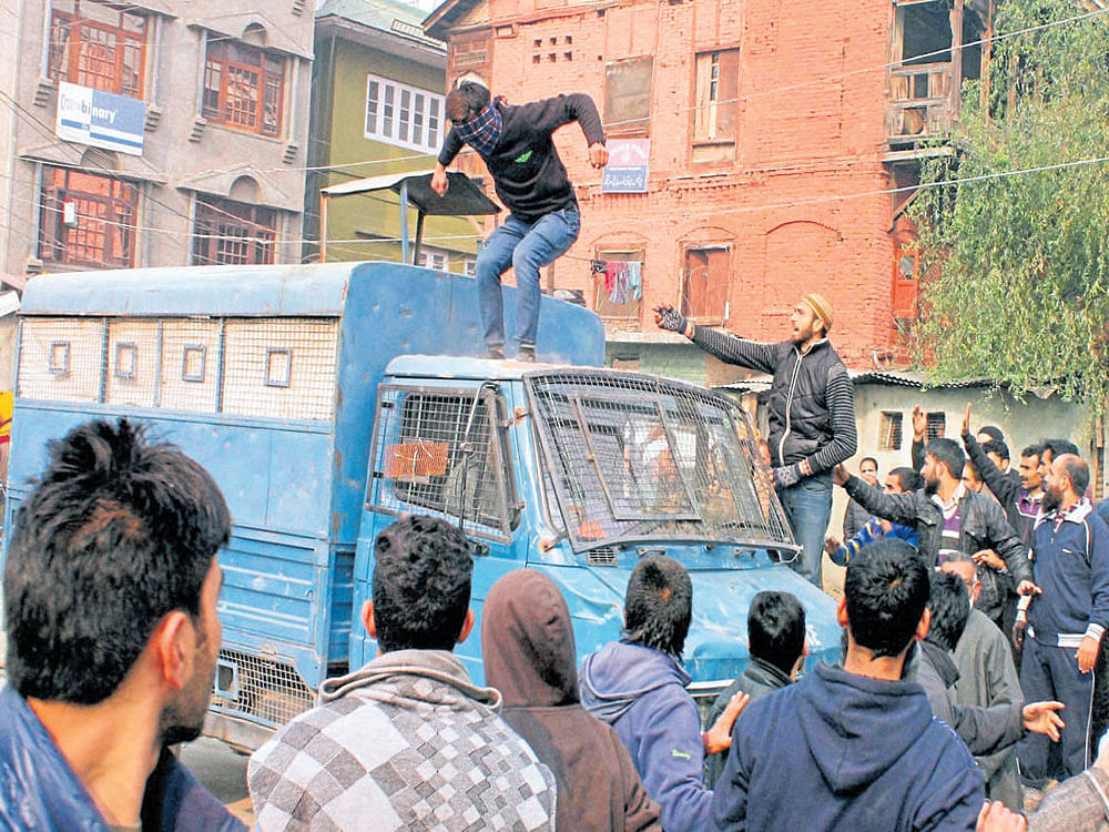 on rampage: Protesters damage a police vehicle during the funeral procession of a youth who died after being knocked down by a security force vehicle at Norah in Srinagar on Monday. PTI