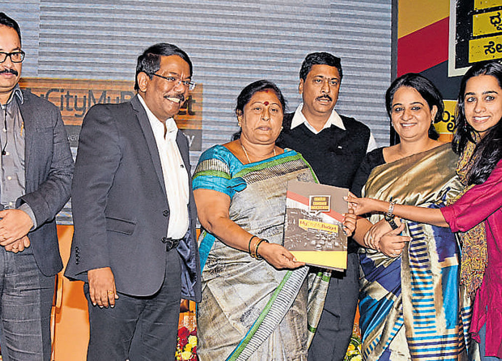 Mayor G Padmavathi receives a copy of the Citizens' Budget 2017-18 from Neeta Reddy during the 'My City My Budget' programme at Town Hall in Bengaluru on Wednesday. DH PHOTO