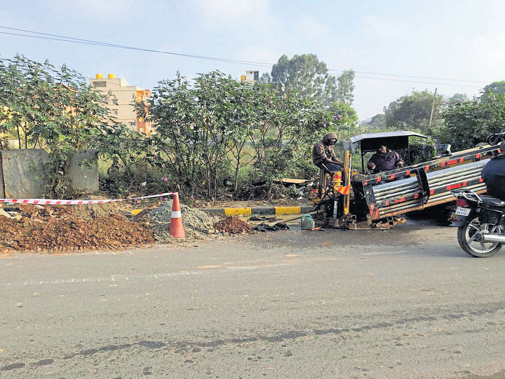 Workers undertake road cutting for laying optical fibre  cables on ECC Road in Whitefield. dh photo