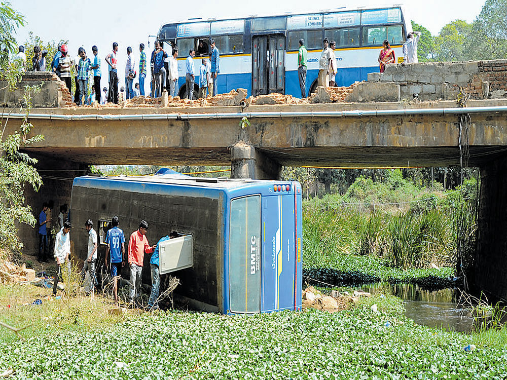 CATASTROPHE AVERTED: The BMTC bus, plying from Kengeri to Nelamangala, which fell off an old bridge near Tavarekere on Friday morning. DH PHOTO