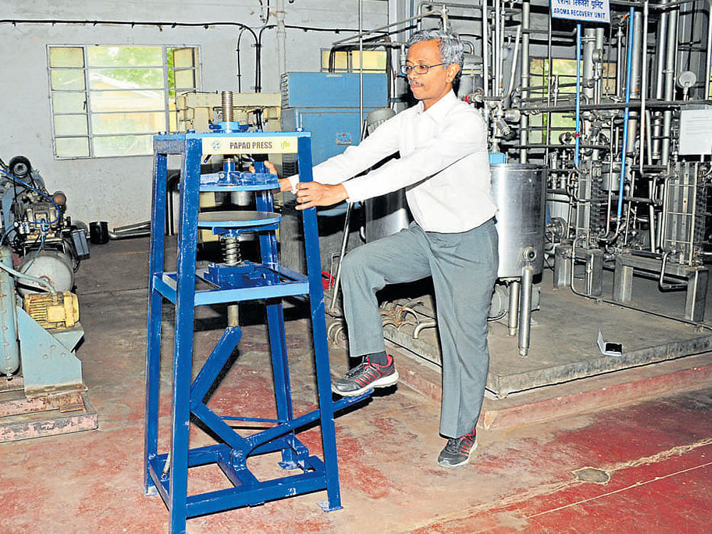 A Central Food Technological Research Institute official demonstrates the functioning of 'Leg Operated Papad Press' on CFTRI&#8200;premises in Mysuru on Thursday. DH photo
