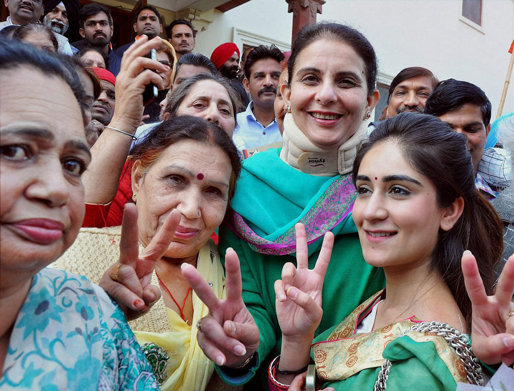 PPCC President Captain Amarinder Singh's daughter Jai Inder Kaur and granddaughter along with Congress supporters flash victory sign as they celebrate the counting trend showing the party's thumping victory in Punjab Assembly polls, in Patiala on Saturday. PTI Photo