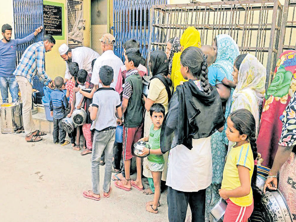 People line up to collect food at Ashiana Food Bank on Mosque Road, Frazer Town, in Bengaluru. DH PHOTOS