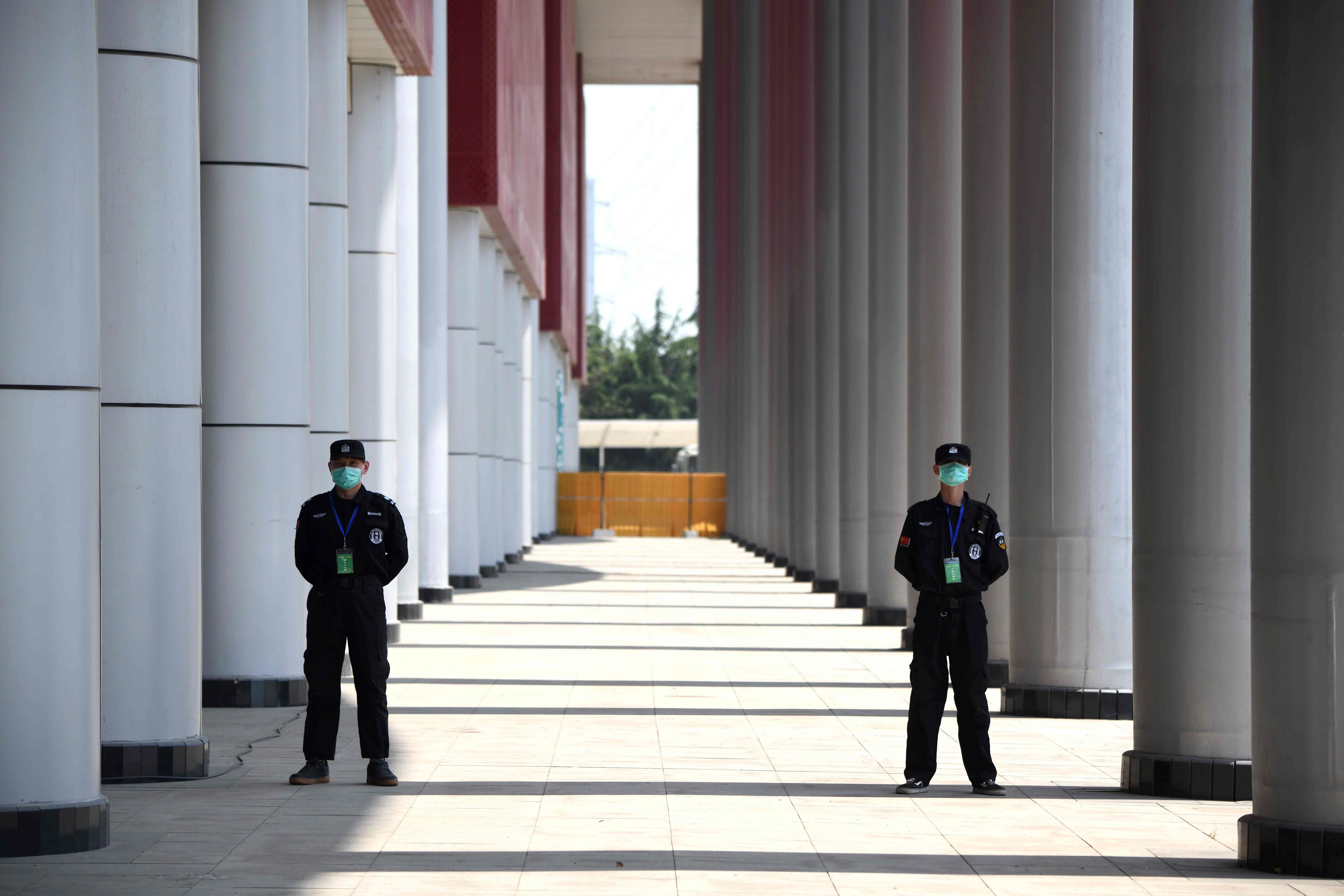 Security personnel stand outside a field hospital that had offered beds for COVID-19 coronavirus patients during the height of the crisis in Wuhan in China’s central Hubei province. (Credit: AFP Photo)