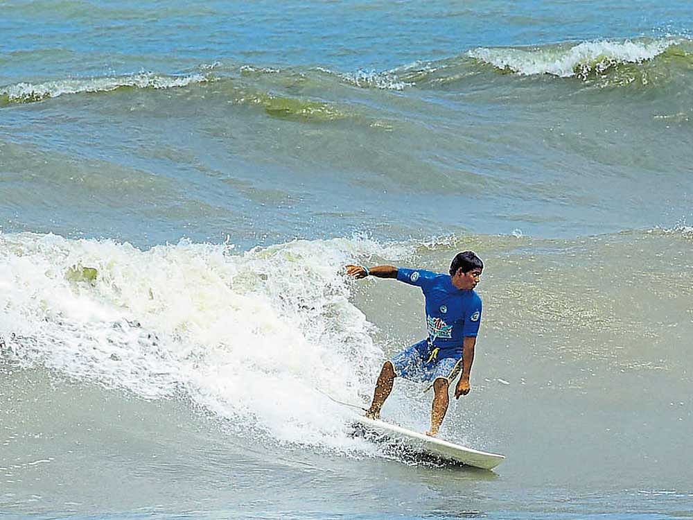 Dharani Selvakumar in action on the second day of the 'Indian Open of Surfing 2017' at Sasihithlu beach on the outskirts of Mangaluru on Saturday. DH Photo/Govindraj Javali