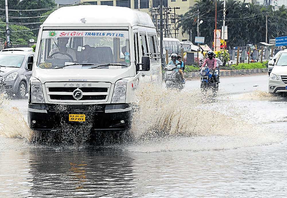 Vehicle users struggle to navigate the waterlogged Hosur Road at Bommanahalli junction following heavy rain on  Friday. dh Photo