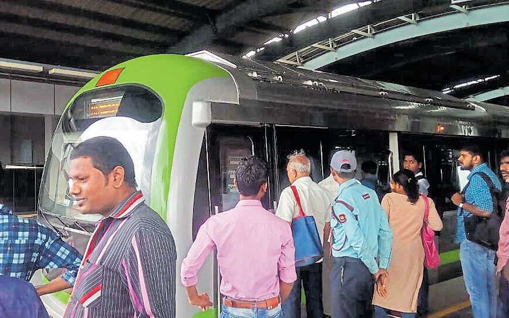 Passengers stranded at Srirampura Metro station after the train was halted due to a technical snag for around 30 minutes on Friday. (inset) The display inside a Metro coach about the delay in service.