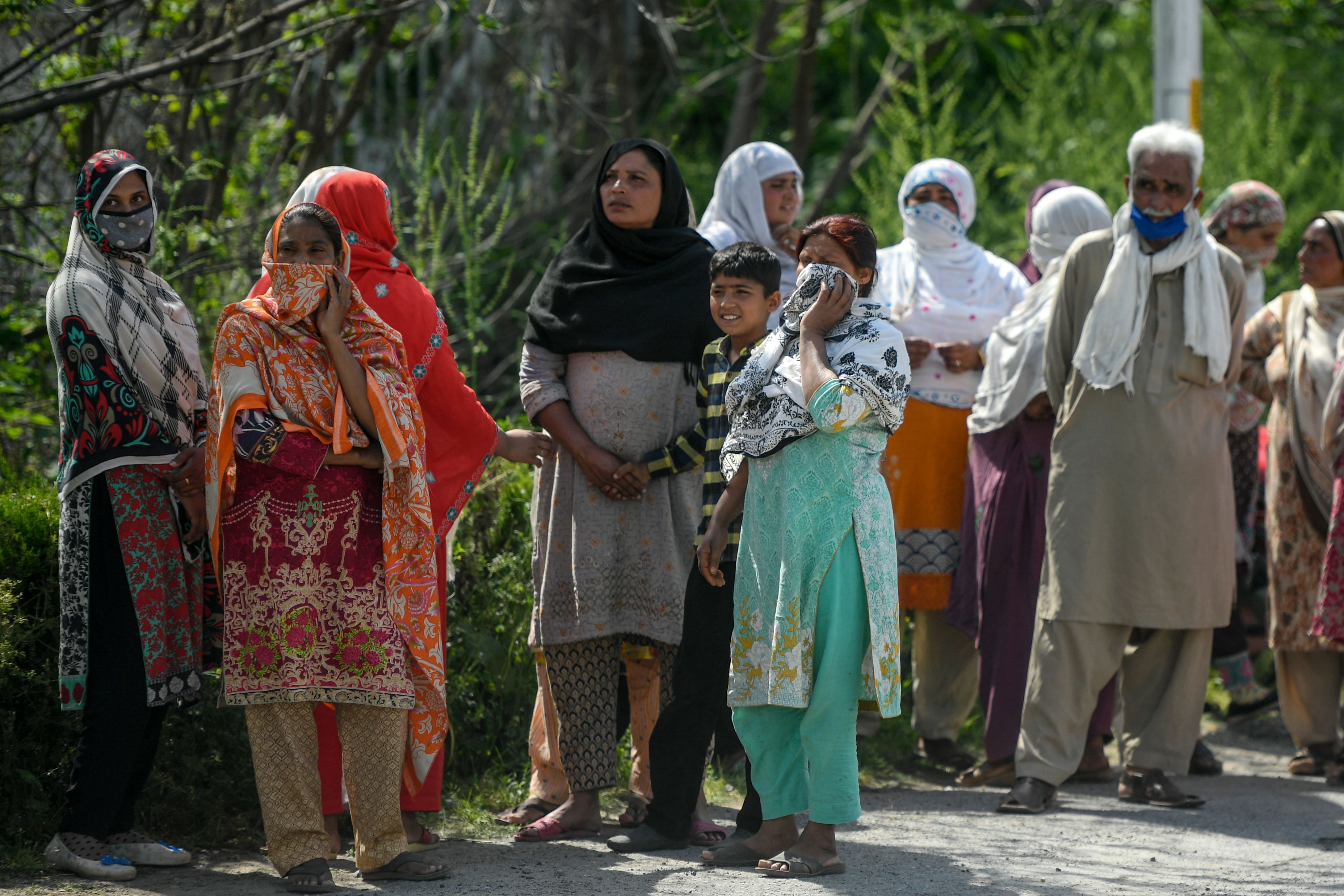 People queue for free food rations at a distribution point during a government-imposed nationwide lockdown as a preventive measure against the COVID-19 coronavirus, in Islamabad. (AFP Photo)