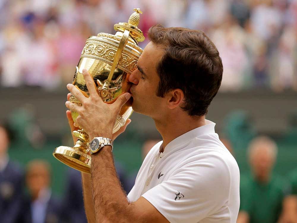 Switzerland's Roger Federer kisses the trophy after defeating Croatia's Marin Cilic to win the Men's Singles final match on day thirteen at the Wimbledon Tennis Championships in London Sunday, July 16, 2017. AP/ PTI
