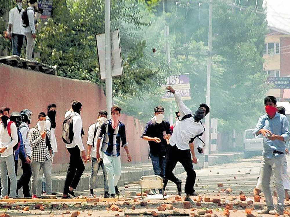 Fresh wave of violence: Students throw stones at the police during clashes outside a college in Srinagar following the killing of most wanted Lashkar-e-Toiba commander Abu Dujana and his associate in the Pulwama encounter. PTI