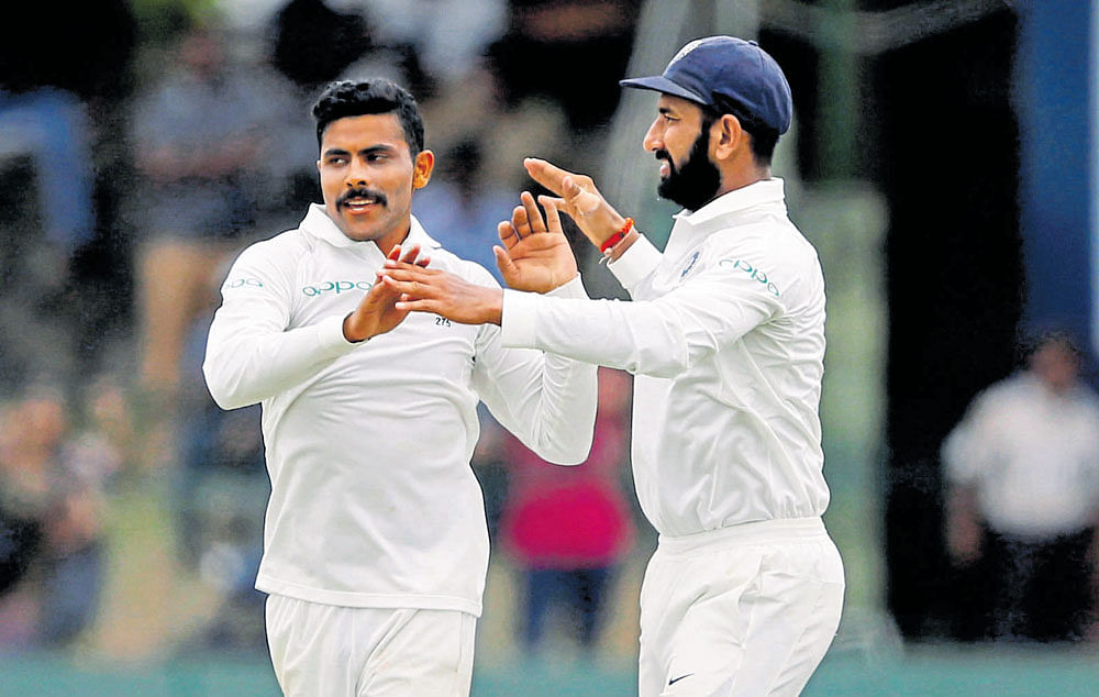 wrecker-in-chief: Ravindra Jadeja (left)&#8200;celebrates with team-mate Cheteshwar Pujara after dismissing Dhananjaya de Silva of Sri Lanka. AFP
