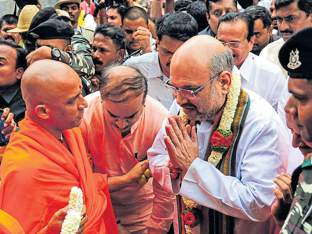 Adichunchanagiri Mutt seer Nirmalanandanatha Swami welcomes BJP president Amit Shah at Adichunchanagiri in Nagamangala taluk, Mandya district, on Sunday. Union Ministers D&#8200;V&#8200;Sadananda Gowda, H&#8200;N&#8200;Ananth Kumar and others look on.