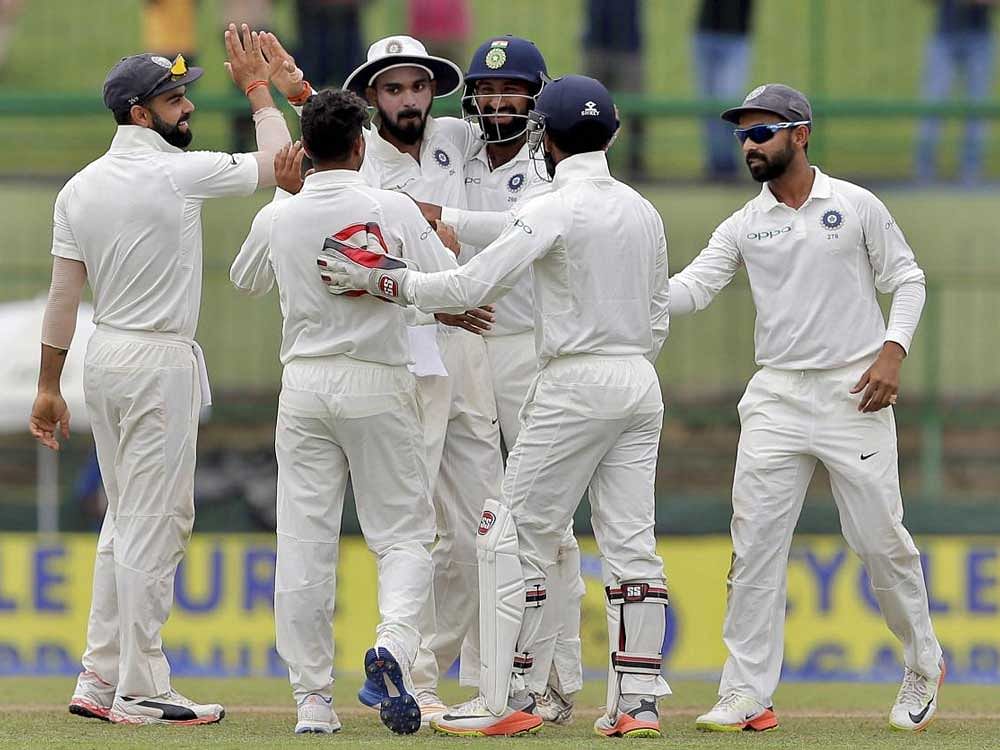 India's Kuldeep Yadav, second left back to camera, celebrates with teammates the dismissal of Sri Lanka's captain Dinesh Chandimal during the third day's play of their third cricket test match in Pallekele, Sri Lanka, Monday, Aug. 14, 2017. AP/PTI Photo
