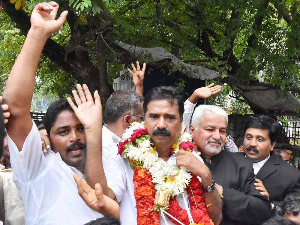 Hartal Halappa and his supporters celebrate his acquittal on the court premises in Shivamogga on Thursday. DH photo