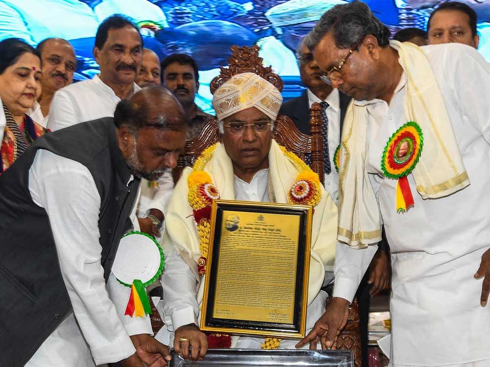 Chief Minister Siddaramaiah presenting Devraj Urs award to the Congress party leader in Loksabha Mallikarjuna Kharge on the occasion of his 102th birth anniversary celebrations of former Chief Minister Devraja Urs, at Vidhana Soudha in Bengaluru on Sunday. Devaraj Urs's daughter Bharati Urs, Ministers K J Gorge, H Anjaneya and others also seen.