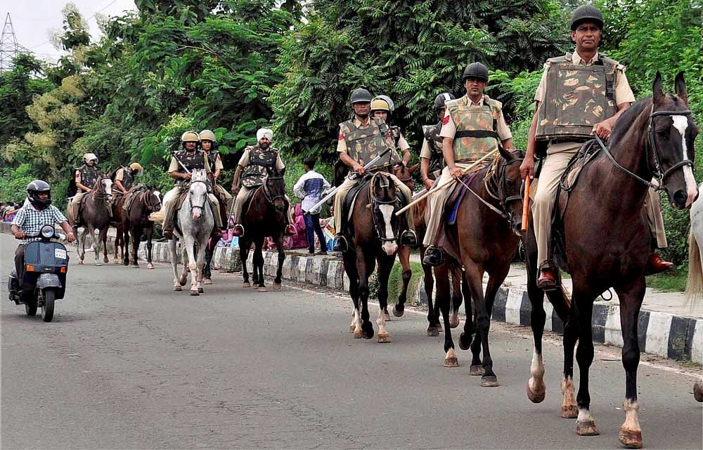 Horse-mounted police personnel at a march in Panchkula on Wednesday. Haryana and Punjab are maintaining high alert ahead of the court judgement in a sexual exploitation case against Dera Sacha Sauda chief Gurmit Ram Rahim Singh, scheduled to be announced on August 25. PTI photo.