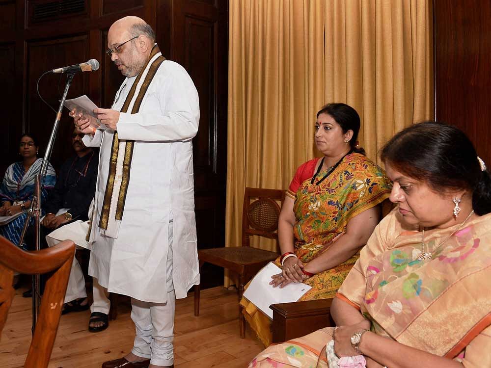 BJP President Amit Shah takes the oath of office as the Rajya Sabha MP at Parliament House in New Delhi on Friday. Shah's wife Sonal Shah is also seen in the picture with Union minister Smriti Irani who also took oath as the Rajya Sabha member.. PTI Photo