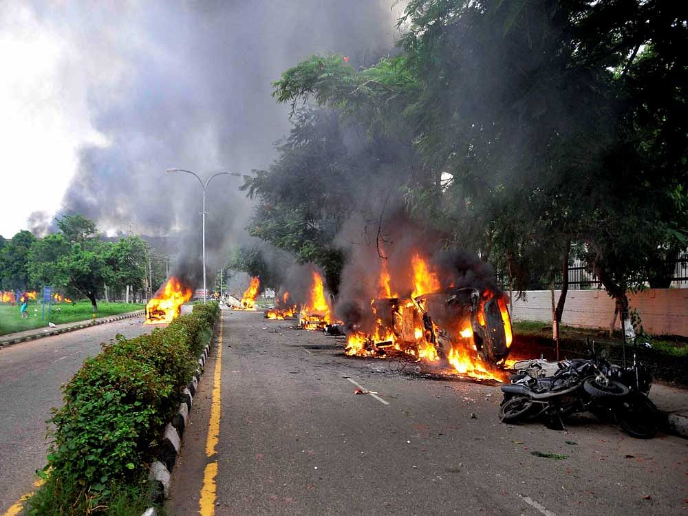 Vehicles burn in violence following Dera Sacha Sauda chief Gurmeet Ram Rahim's conviction in Panchkula on Friday. PTI photo