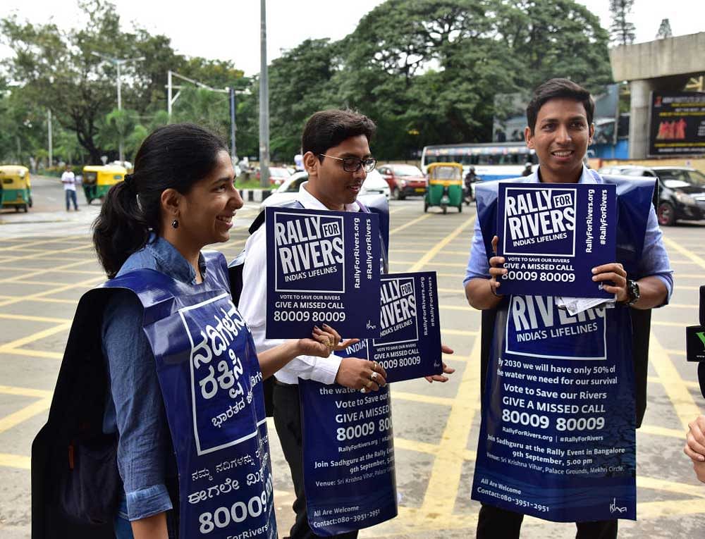 Volunteers of Isha Foundation hold placards to raise awareness about saving rivers, on MG Road. DH photo