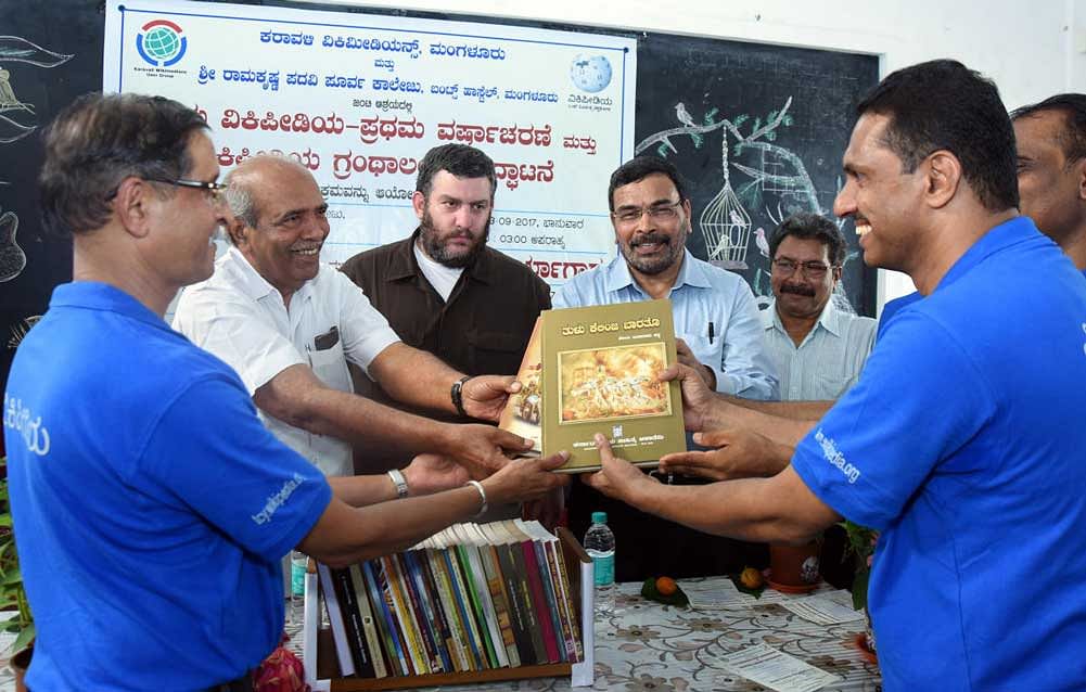 Karnataka Tulu Sahitya Academy Chairman A&#8200;C Bhandary symbolically hands over the reference books to the Wikipedia Library, during the inauguration of Wikipedia Library at Sri Ramakrishna P U College in Mangaluru on Sunday. Folklore University (Haveri) former&#8200;Vice Chancellor Prof K Chinnappa Gowda looks on. DH Photo