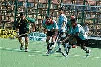 Army Green and MLI teams striving for the possession of the ball at the State-level Super Division Hockey League Championship in Madikeri on Saturday. DH Photo