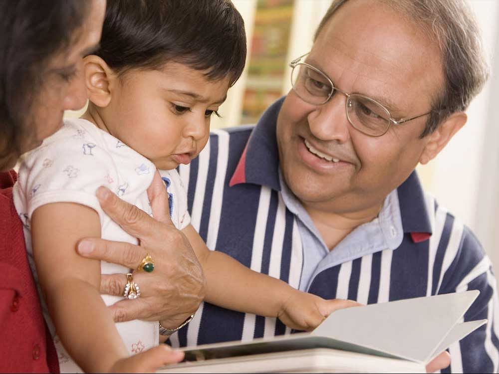 Close-up of grandparents reading a book with their grandson