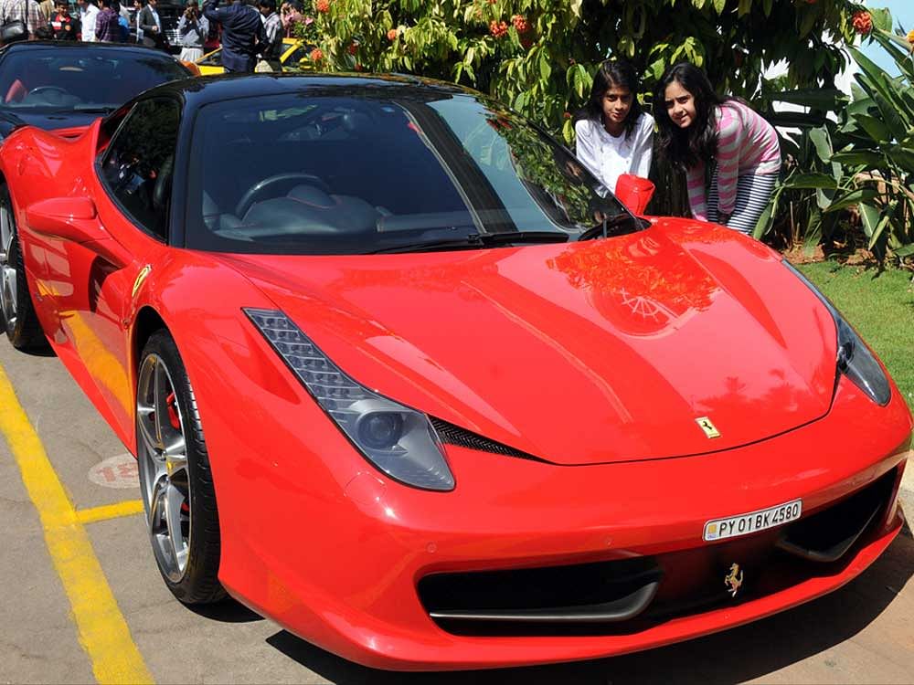 For luxury motor fanatics and punters alike, there is something 'magic' about Ferraris and their distinctive sound. Representational image. Children looking Ferrari sports car at Exotic cars display programme organised by Bangalore Club in Bangalore on Sunday. Photo by S K Dinesh. Credit: DH photo.