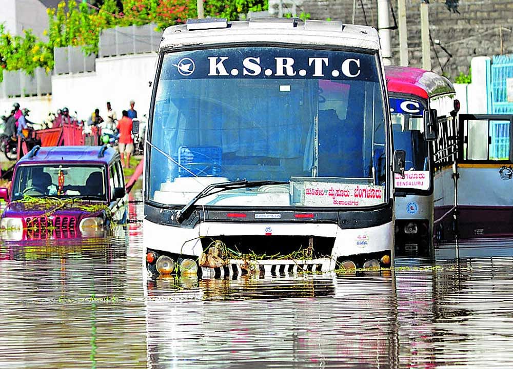 A number of vehicles were stranded on the busy Mysuru Road near the Kengeri bus stand on Sunday, following heavy rain on Saurday night. DH Photo/Ranju P