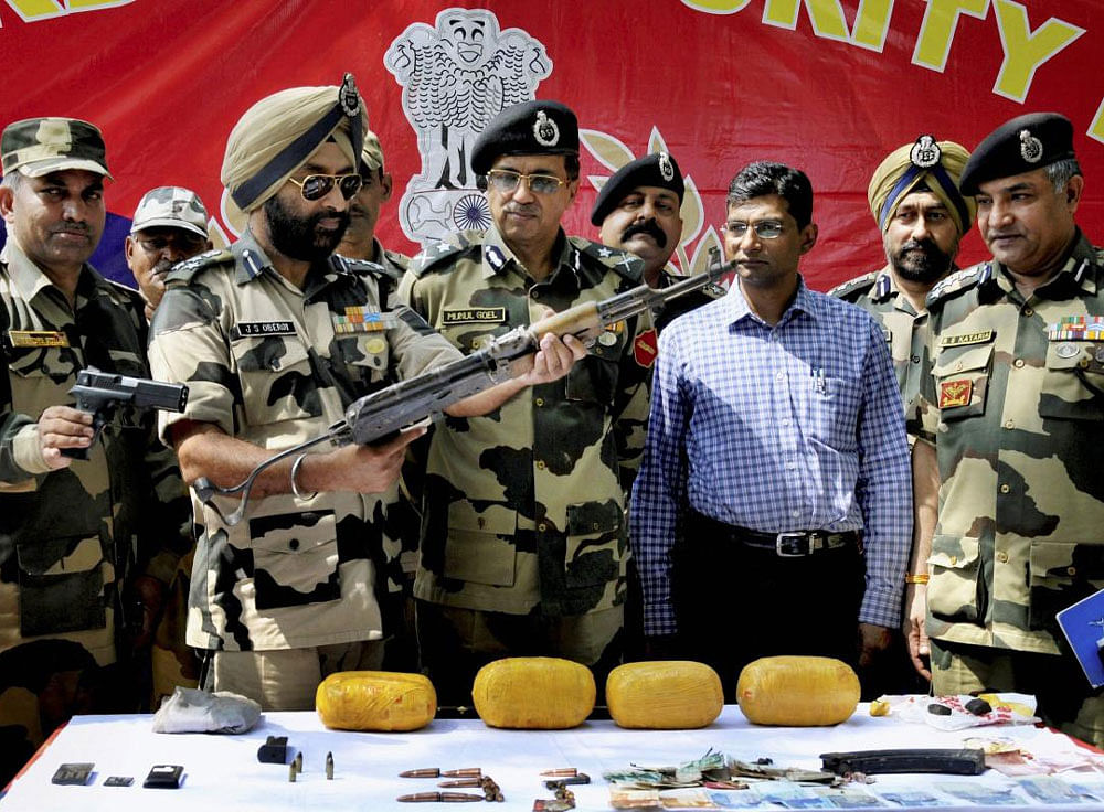 Border Security Force (BSF) IG Mukul Goel and other officers show the arms, bullets and other items recovered from the two Pakistani infiltrators who were killed at the India-Pakistan border, some 40 km from Amritsar, on Wednesday. PTI Photo
