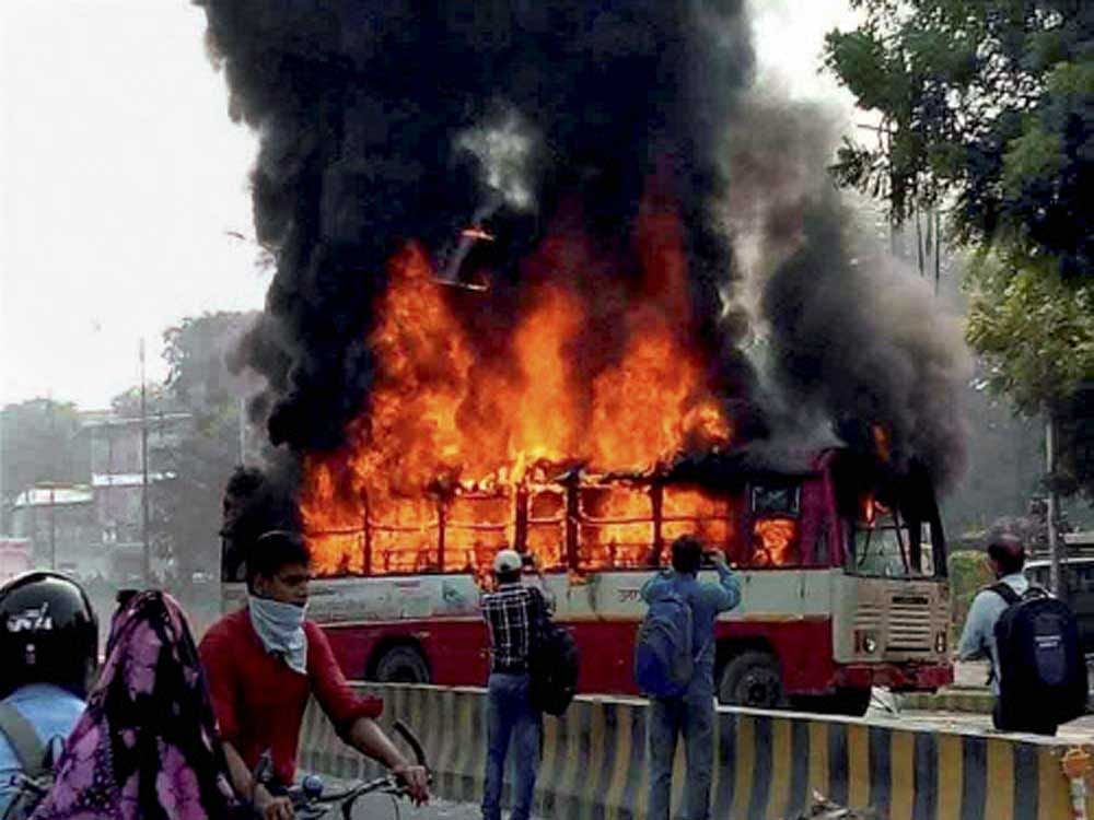 Angry relatives and people set ablaze a UP Roadways bus during a protest against the murder of BSP leader Rajesh Yadav, in Allahabad on Tuesday. Yadav was shot dead at the Allahabad University's Tara Chandra Hostel on Monday night. PTI Photo