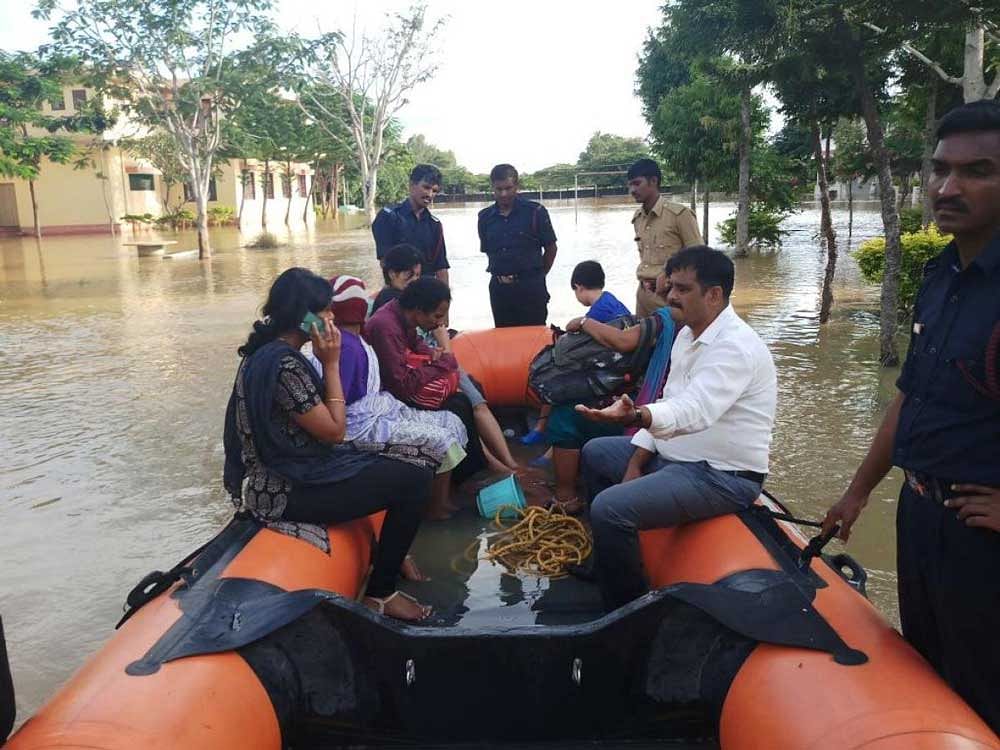 The personnel of the Karnataka State Disaster Response Force rescue children and school staff stranded in the marooned private school in Kolar on Wednesday. DH photo