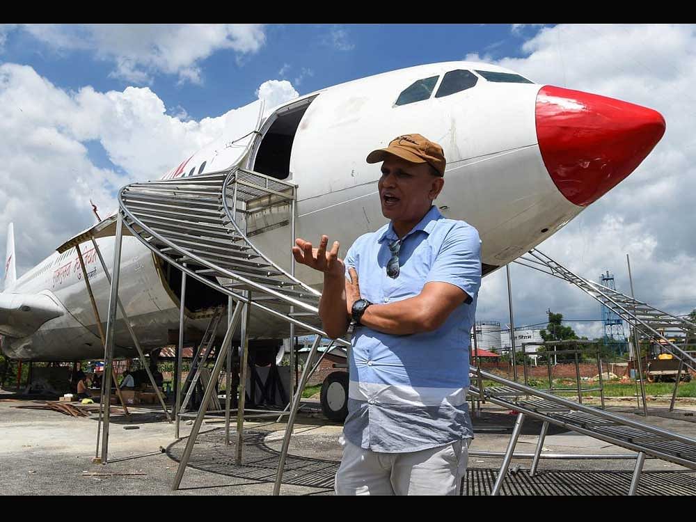 In this photograph taken on July 18, 2017 Nepali pilot Bed Upreti talks during an interview with AFP in front of an airplane that has been converted into an aviation museum in Kathmandu. A Turkish Airlines plane that crash landed at Kathmandu airport two years ago is preparing to once again welcome ticket holders on board not for a flight but for a visit to the Nepali capital's first aviation museum. AFP PHOTO