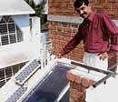 aware A R Shivakumar beside a roof integrated solar  water heater installed at his residence.