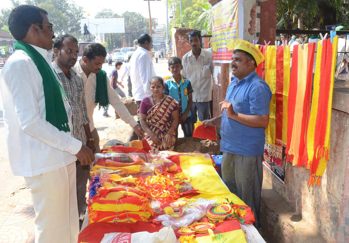 People buying Kannada flags, at Channamma Circle, in Belagavi, on the eve of Karnataka Rajyotsava on Wednesday.