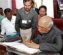Governor H R Bhardwaj signing census form in Raj Bhavan, Bangalore on Thursday. DH Photo