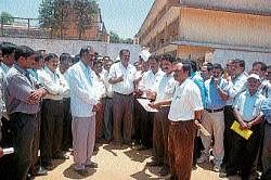 High School teachers who boycotted valuation of SSLC answer scripts submitting a memorandum to DDPI Narasimhaiah in Madikeri on Thursday. DH Photo