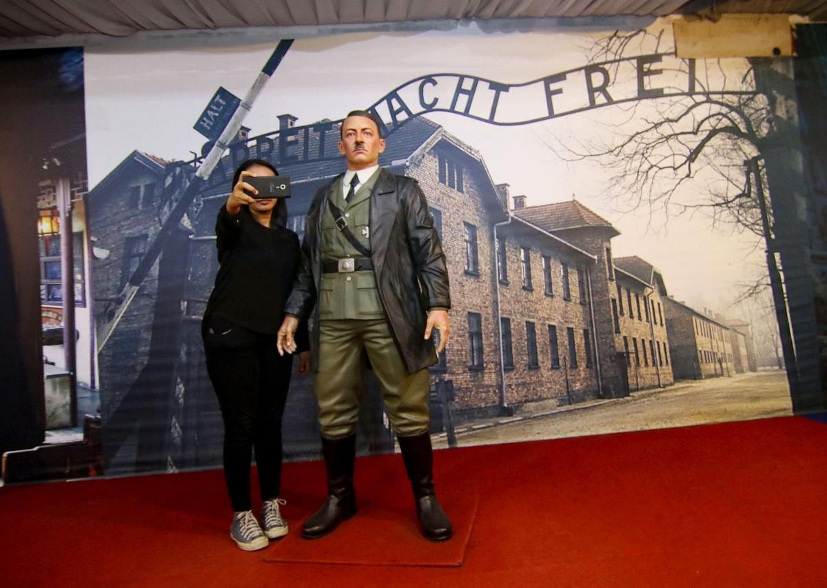 This photograph shows a woman taking a selfie with a lifesize wax sculpture of Adolf Hitler at a museum in Yogyakarta. An Indonesian museum that allowed visitors to take selfies with a lifesize wax sculpture of Hitler against a backdrop of Auschwitz concentration camp has removed the exhibit following international outrage. AFP