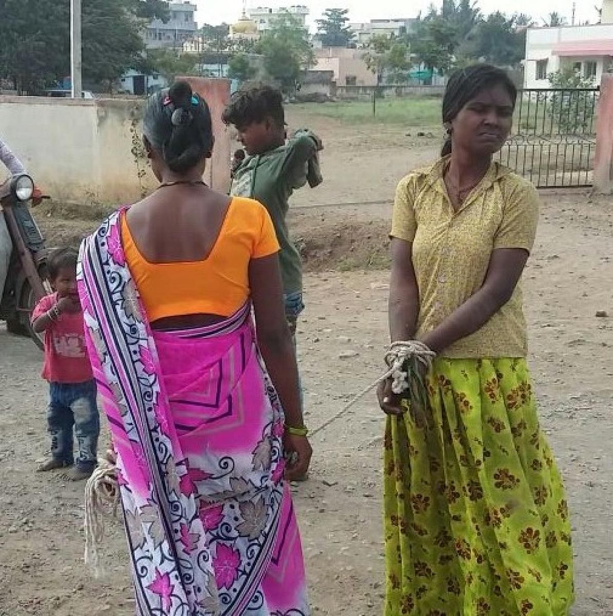 A girl with her hands tethered with rope being dragged by family members to a black magician, at Athani, on Saturday. DH Photo