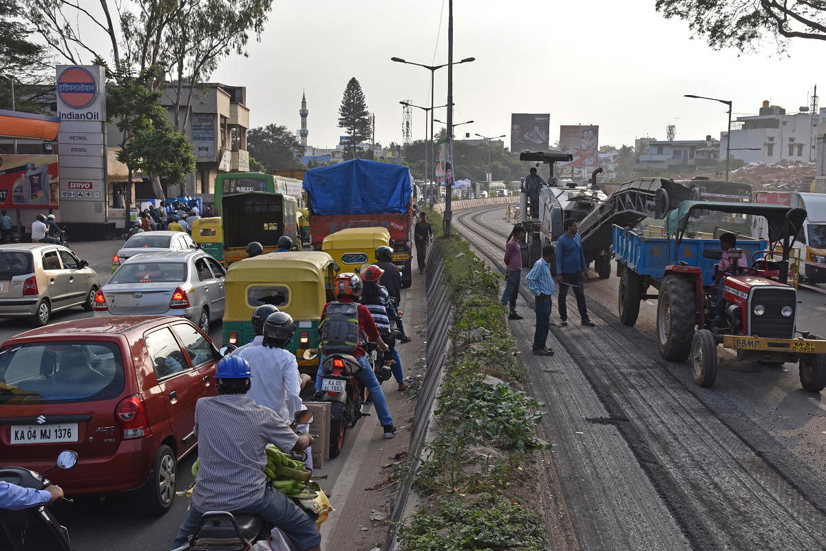Slow moving traffic is seen at Guddahalli during KR market to BHEL (deepagali nagar) road white tapping work started in Mysuru road, Bengaluru on Monday. Photo by S K Dinesh