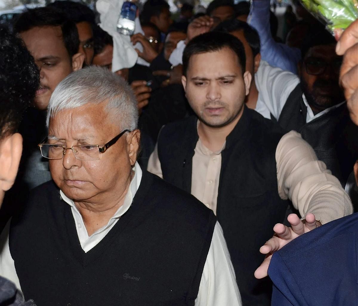 RJD Chief Lalu Prasad and his son Tejashwi Yadav seen at Patna airport as he leaves for Ranchi where a special CBI judge is expected to pronounce judgment in fodder scam case, in Patna on Friday. PTI