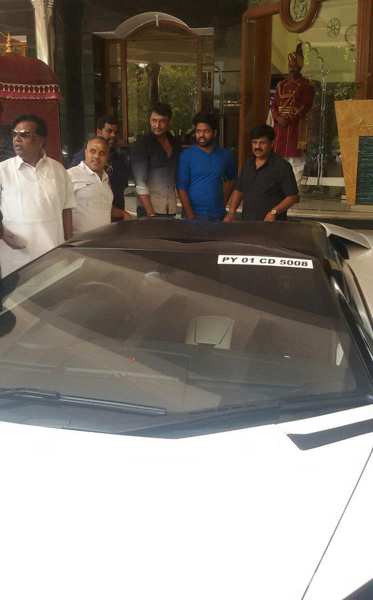 Actor Darshan seen with his new Lamborghini car in Mysuru on Tuesday. MLC Sandesh Nagaraj and Corporator Sandesh Swamy are seen. DH PHOTO