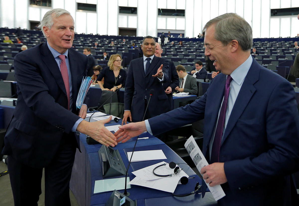 European Union's chief Brexit negotiator Michel Barnier (L) shakes hands with Brexit campaigner and Member of the European Parliament Nigel Farage as he arrives to attend a debate on the Future of Europe at the European Parliament in Strasbourg, France, January 17, 2018. REUTERS