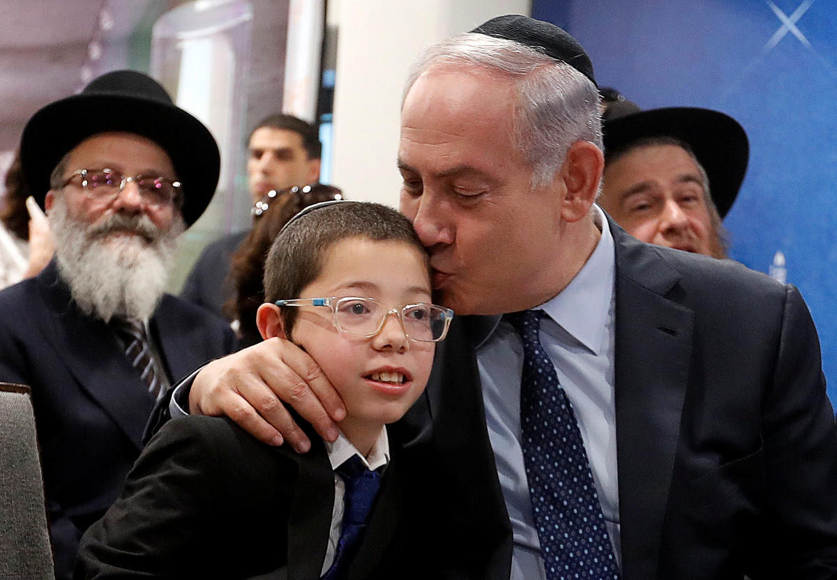 Israeli Prime Minister Benjamin Netanyahu kisses Moshe Holtzberg at the Chabad House in Mumbai on Thursday. REUTERS